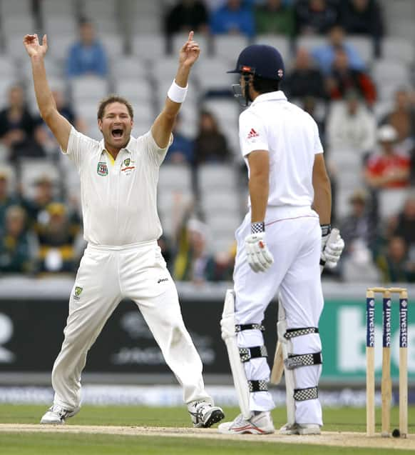 Australia's Ryan Harris, left, celebrates the wicket of England's captain Alastair Cook, right, during day five of the third Ashes Test match held at Old Trafford cricket ground in Manchester, England.