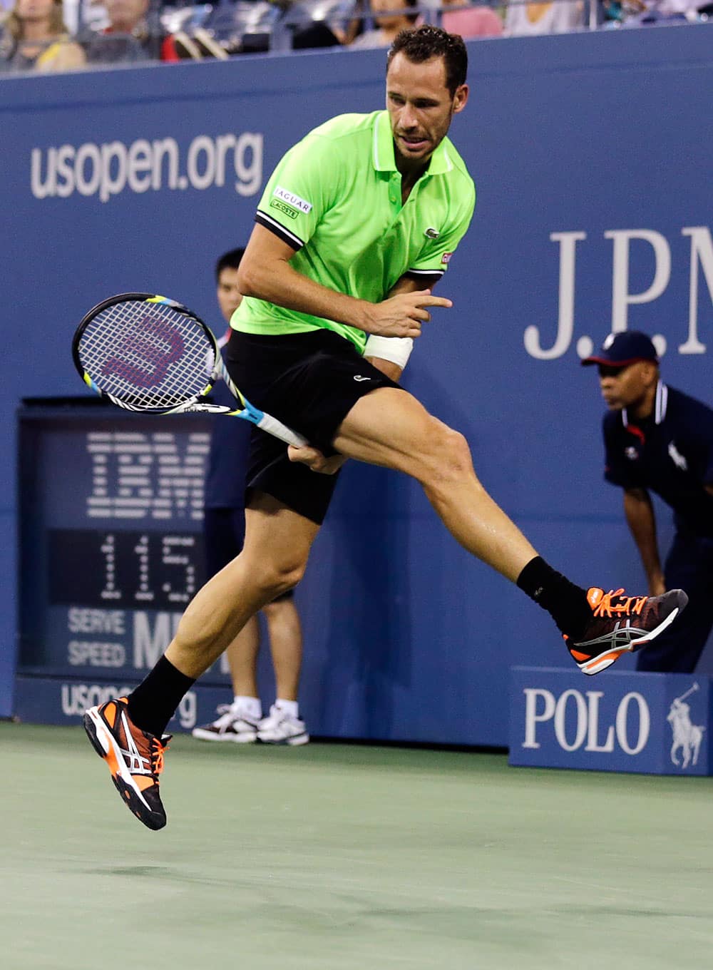 Michael Llodra, of France, follows through on a return between his legs against Andy Murray, of Britain, in the first round of the 2013 US Open tennis tournament.