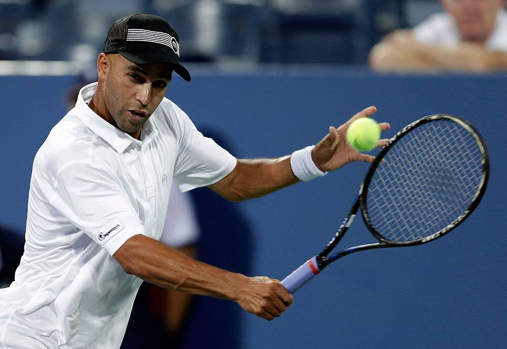 James Blake returns a shot to Ivo Karlovic, of Croatia, during the first round match of the US Open tennis tournament.