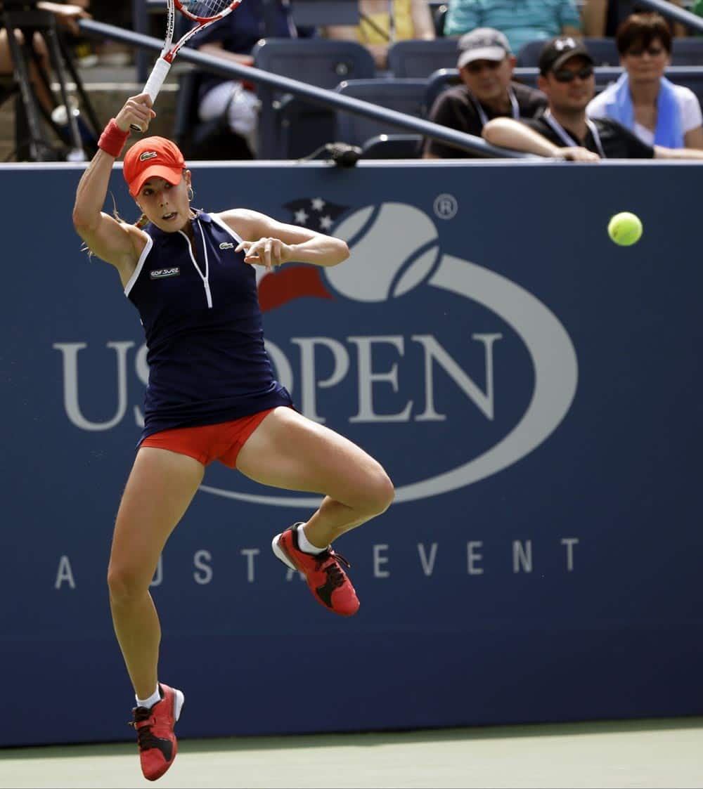 Alize Cornet, of France, returns a shot to Victoria Azarenka, of Belarus, during the third round of the 2013 US Open tennis tournament.