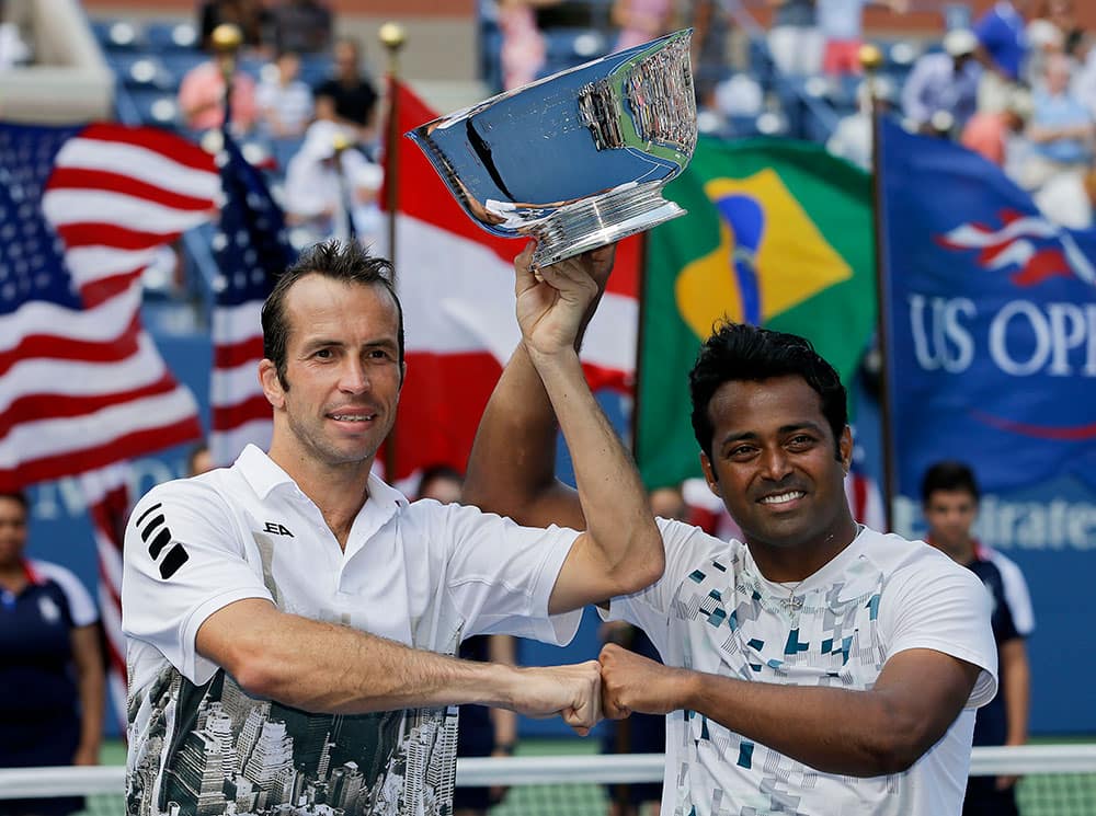 Radek Stepanek, of the Czech Republic, left, and Leander Paes, of India, hold up the championship trophy after defeating Alexander Peya, of Austria, and Bruno Soares, of Brazil, in the men's doubles final of the 2013 US Open tennis tournament.