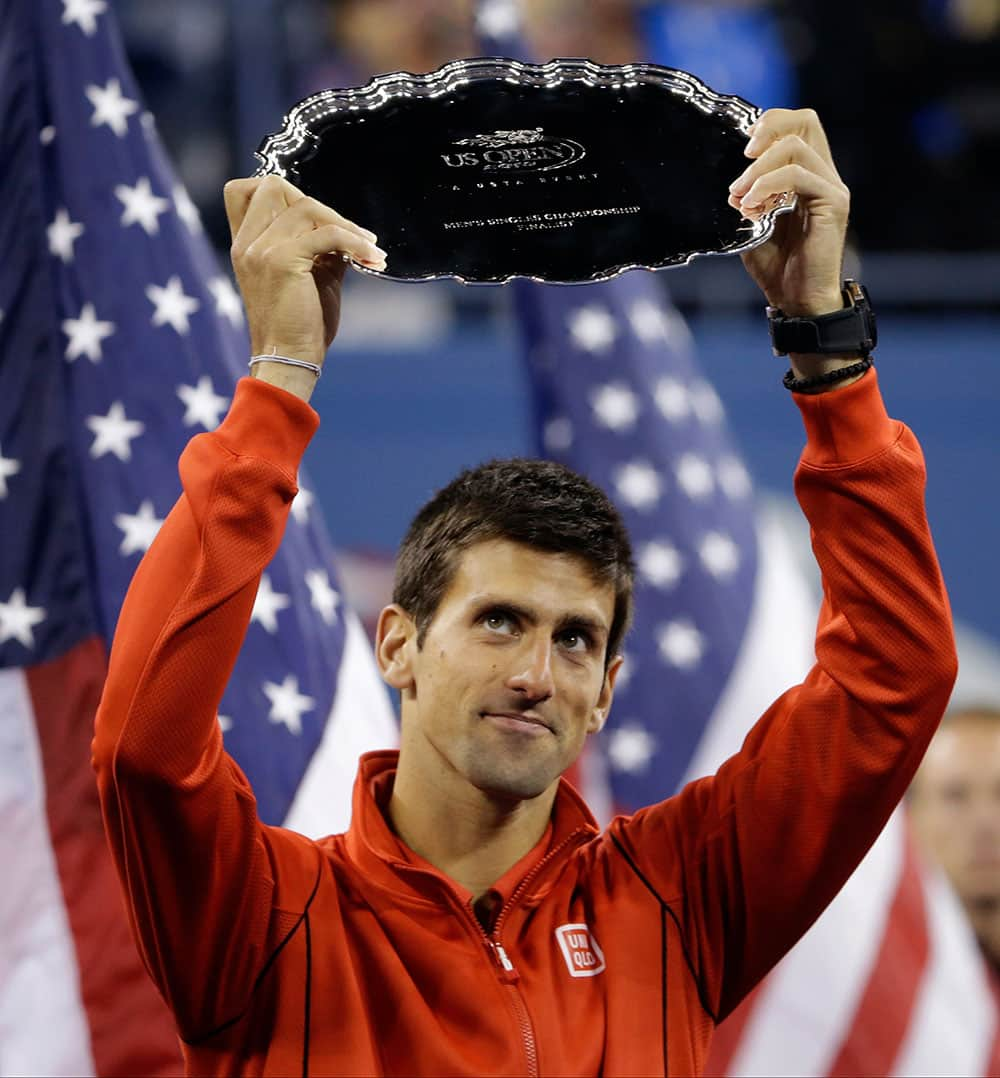 Novak Djokovic, of Serbia, holds up the second place trophy after losing to Rafael Nadal, of Spain, during the men's singles final of the 2013 US Open tennis tournament.