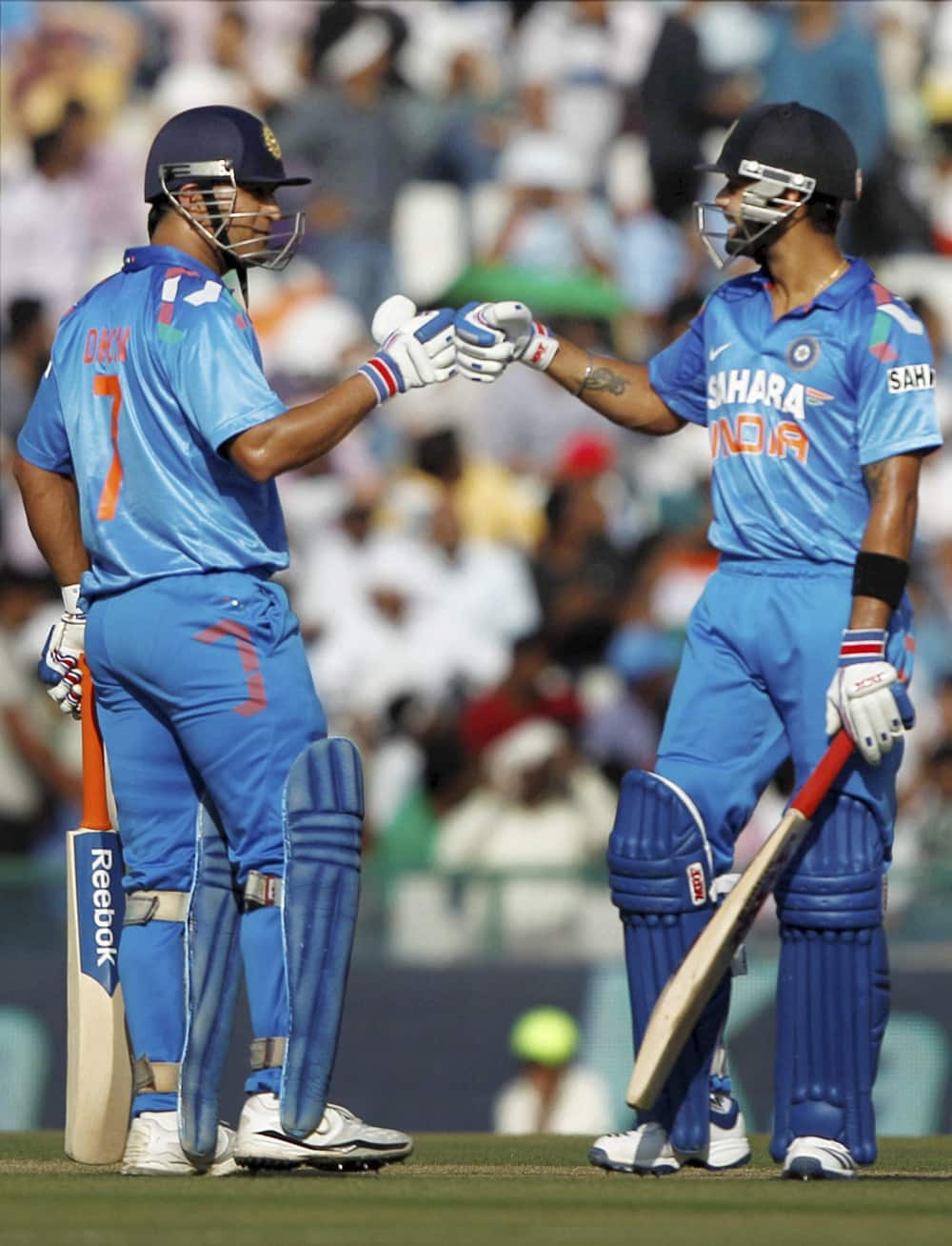 MS Dhoni and Virat Kohli celebrate a boundary during the 3rd ODI cricket match against Australia at PCA stadium in Mohali.