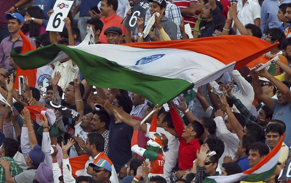 Spectators jubilate with a Tricolour during the 3rd ODI cricket match between India and Australia at PCA stadium in Mohali.