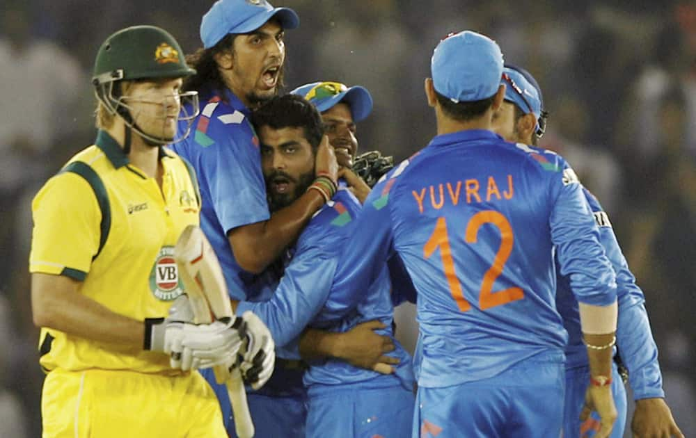 R Jadeja celebrates with teammates after taking the wicket of Australian batsman S Watson during the 3rd ODI cricket match at PCA stadium in Mohali.