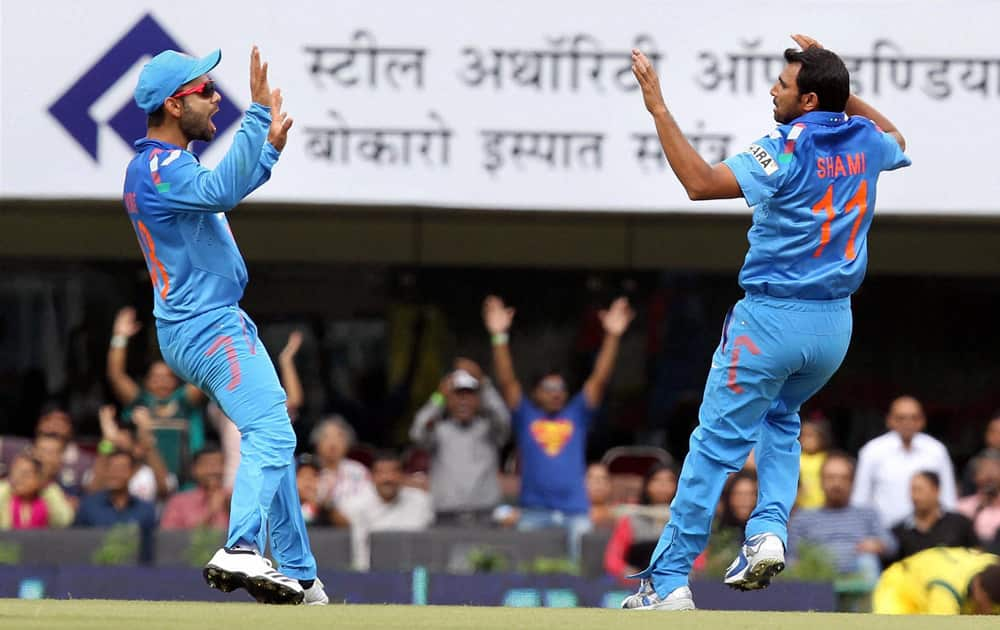 M Shami (R) reacts along with Virat Kohli after claiming the wicket of Australia's A Finch during the 4th ODI cricket match in Ranchi.