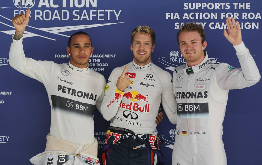 Red Bull driver Sebastian Vettel, centre,of Germany gestures after taking pole position in qualifying at the Indian Formula One Grand Prix at the Buddh International Circuit in Noida.