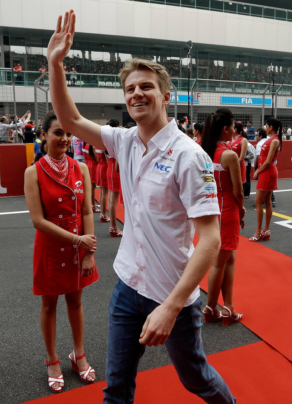 Sauber driver Nico Hulkenberg of Germany waves to the crowd as he walks onto the track for the drivers parade prior to the start of the Indian Formula One Grand Prix at the Buddh International Circuit in Noida.