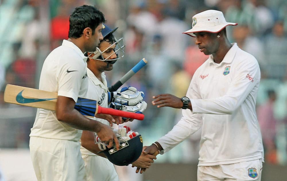 Rohit Sharma and R Ashwin walk back from the field at the end of the Second day of their first test cricket match against West Indies at Eden Garden in Kolkata.