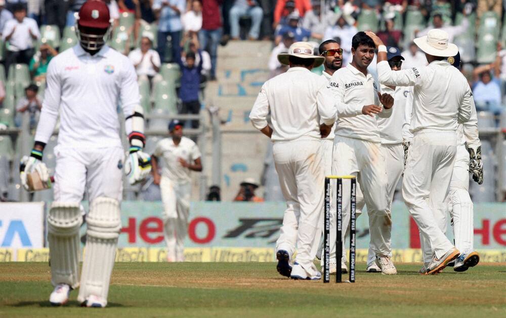 P Ojha celebrates with teammates after dismissing a West Indies batsman during Day 1 of the 2nd and final test match at Wankhede in Mumbai.