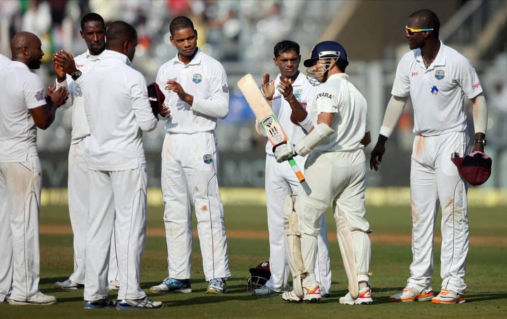 West Indian players clap to pay their respect to Indian batsman Sachin Tendulkar as he arrives to bat on Day 1 of their 2nd test match at Wankhede Stadium in Mumbai on Thursday. Tendulkar is playing his last 200th Test match.