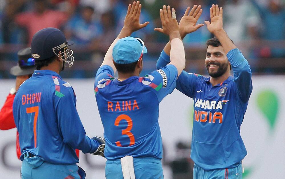 Ravindra Jadeja celebrates the wicket of Darren Sammy of West Indies with Suresh Raina and Mahendra Singh Dhoni during the 1st ODI in Kochi.