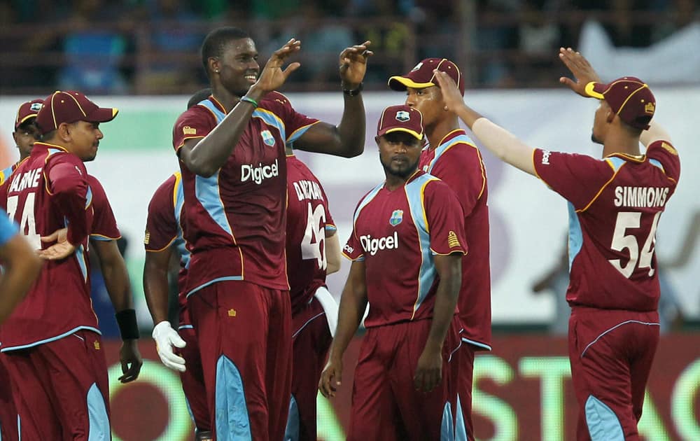 West Indies bowler Jason Holder with team mates celebrates the wicket of Shikhar Dhawan of India during the 1st ODI cricket match in Kochi.