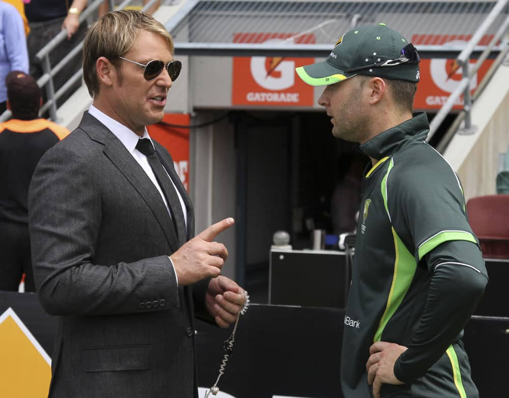 Former Australian cricket player Shane Warne, left, talks to Australian captain Michael Clarke before the start of play on the third day of the series-opening Ashes cricket test between England and Australia at the Gabba in Brisbane.