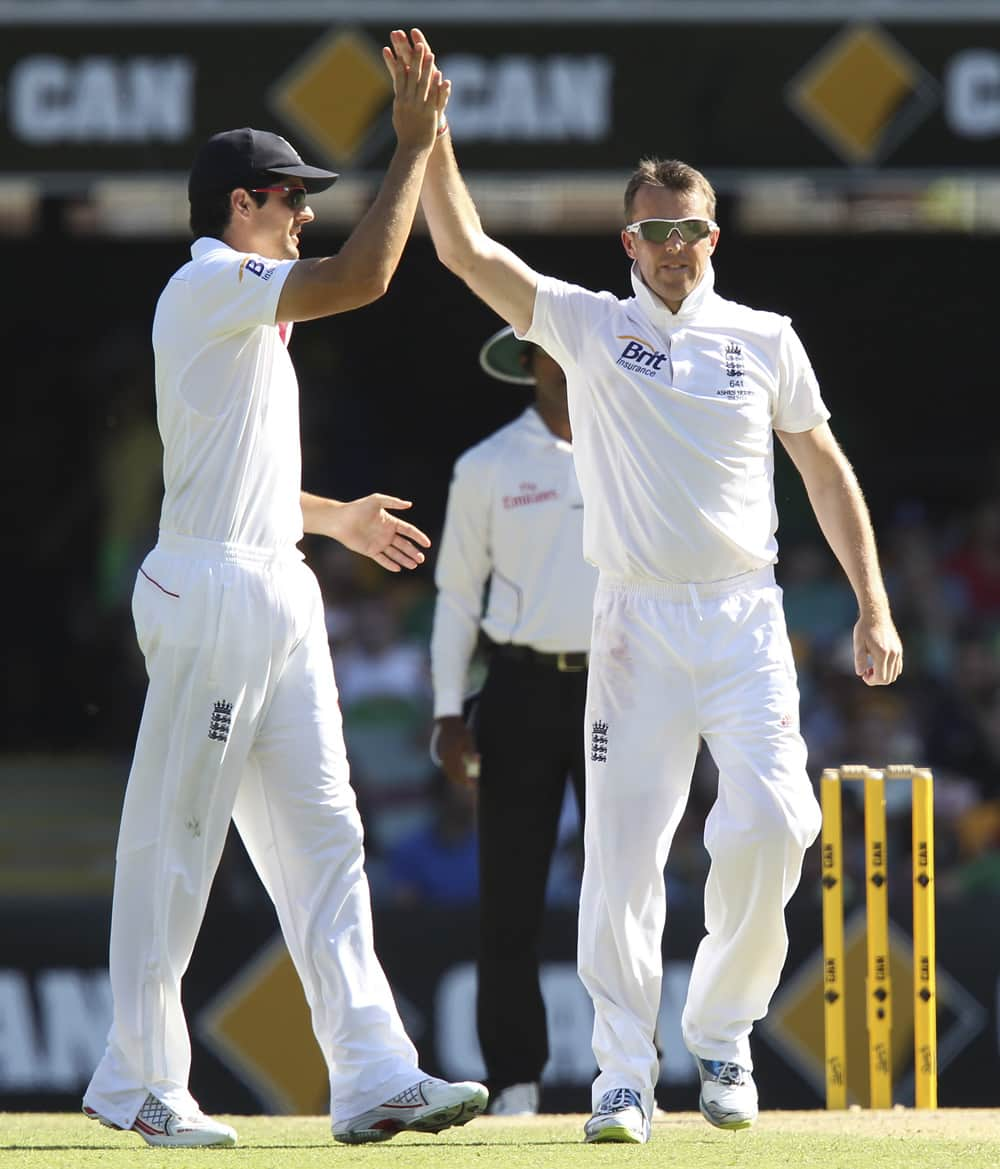 Alastair Cook celebrates with Graeme Swann after Swann got the wicket of George Bailey on the third day of the series-opening Ashes cricket test at the Gabba in Brisbane, Australia.