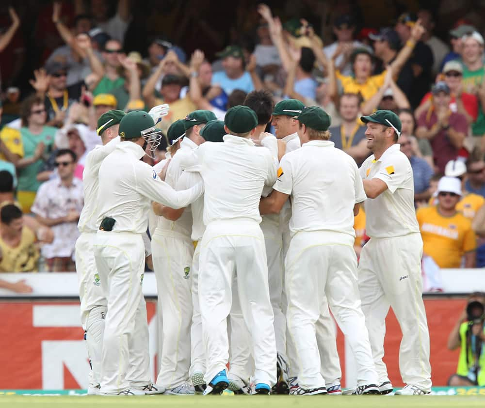 Australia celebrate after the wicket of England's Jonathan Trott, on the third day of the series-opening Ashes cricket test at the Gabba in Brisbane, Australia.