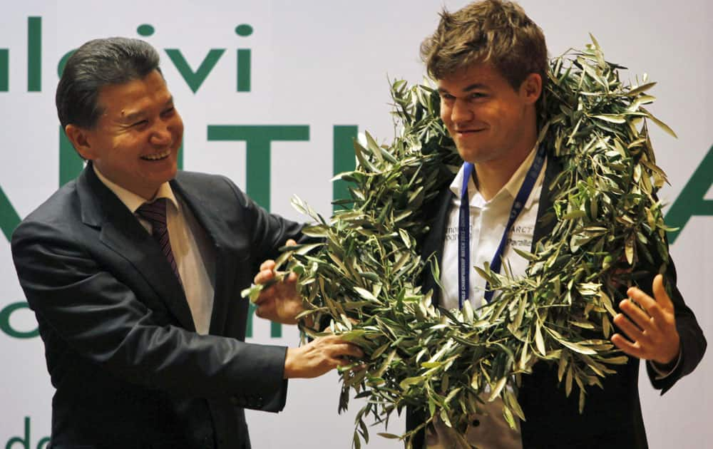 World Chess Federation President Kirsan Ilyumzhinov, left, presents new world chess champion Magnus Carlsen of Norway with a laurel wreath at the award presentation ceremony of the FIDE World Chess Championship in Chennai.