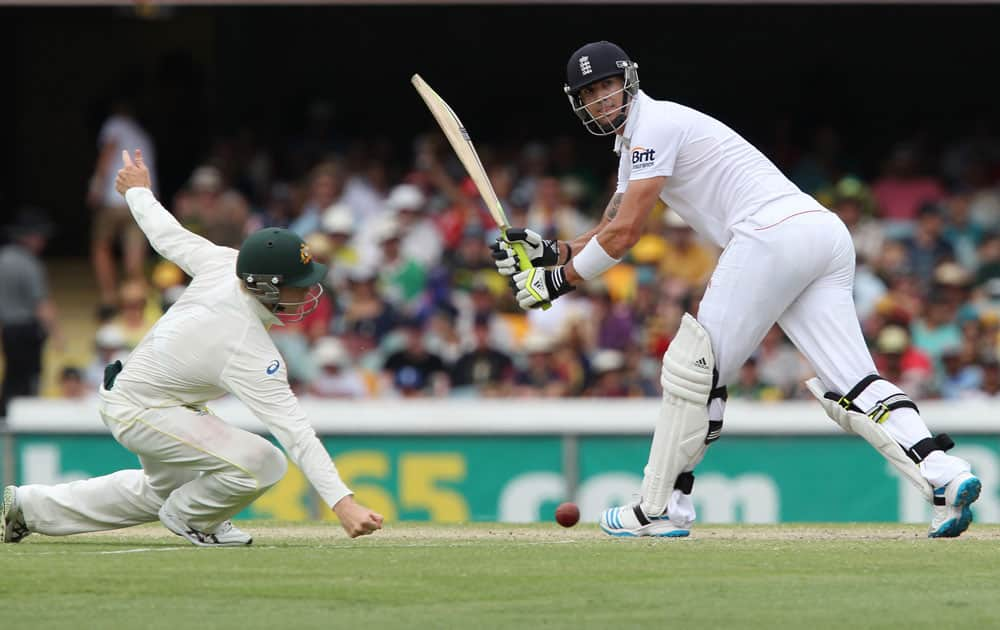 England's Kevin Pietersen, right, plays a shot past Australia's Steven Smith, left, on the fourth day of the series-opening Ashes cricket test between England and Australia at the Gabba in Brisbane.