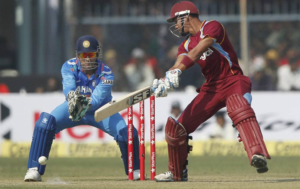 M S Dhoni looks on as West Indies batsman L Simmons plays a shot during the last ODI match between India and West Indies at Green Park stadium in Kanpur.