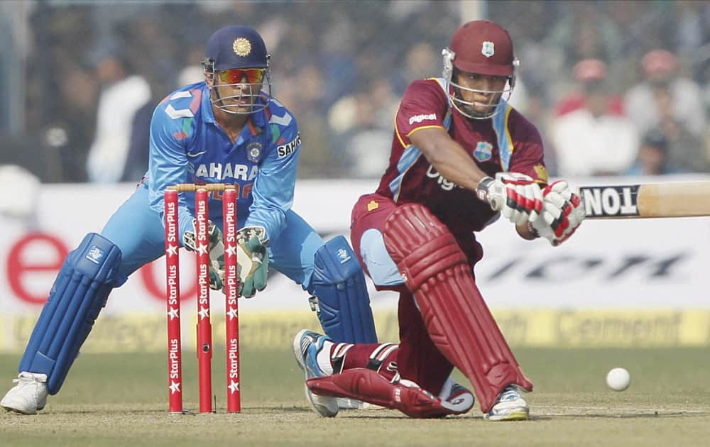 M S Dhoni looks on as West Indies batsman KOA Powell plays a shot during their last ODI match at Green Park stadium in Kanpur.