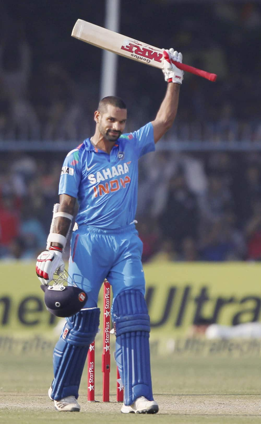 Shikar Dhawan raises the bat after his century during the last ODI cricket match against West Indies at Green Park Stadium in Kanpur.