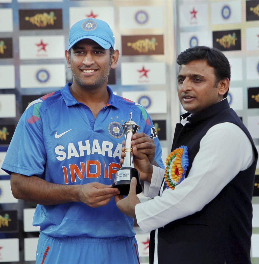 UP Chief Minister Akhilesh Yadav presenting the winner's trophy to Indian captain M S Dhoni at the presentation ceremony after the last ODI cricket match between India and West Indies, at the Green Park stadium in Kanpur.