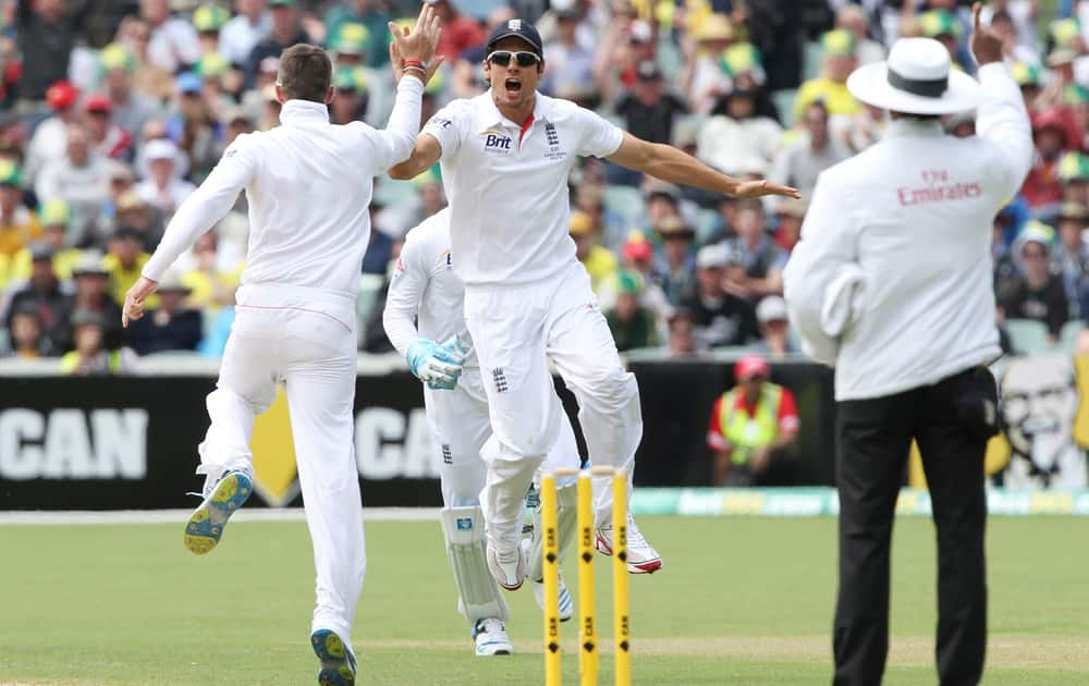 Graeme Swann and Alistair Cook celebrate the wicket of Australia's Chris Rogers during their second Ashes cricket test match in Adelaide, Australia.