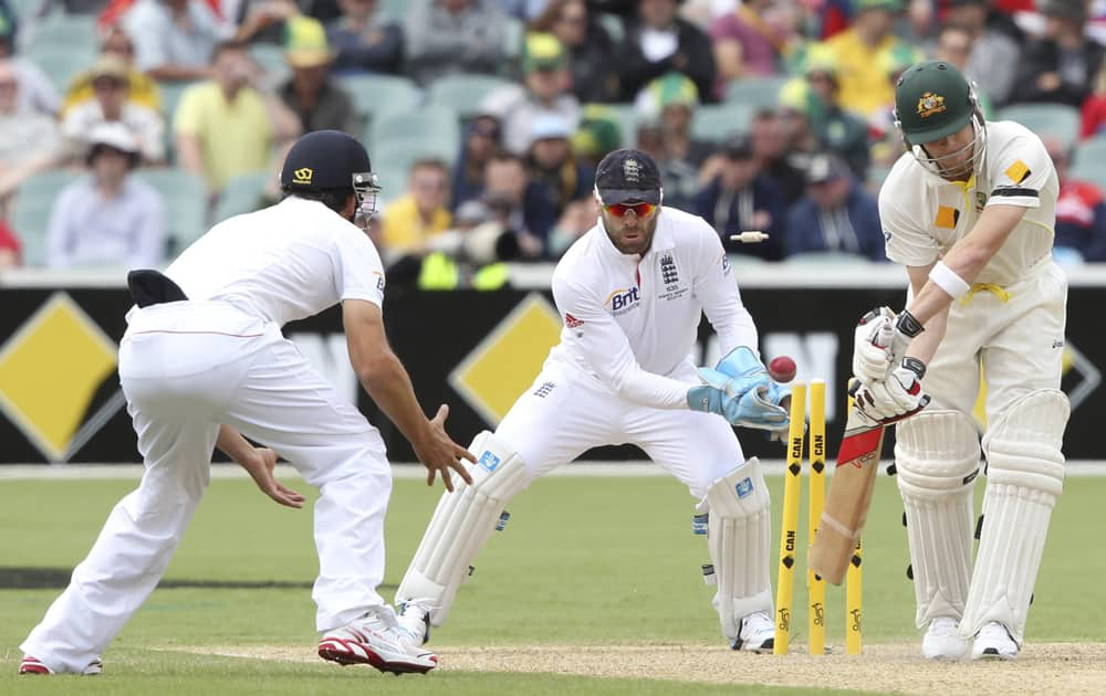 Steven Smith is bowled as England's Alistair Cook and Matt Prior field during their second Ashes cricket test match in Adelaide, Australia.