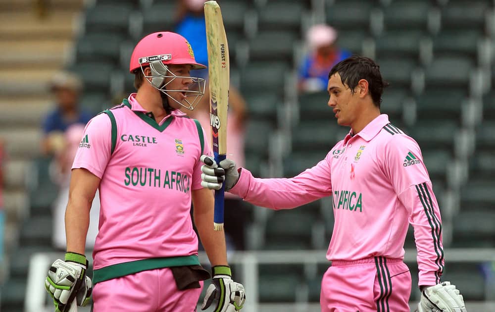 South Africa's Quinton de Kock, raises his bat after reaching a century as captain A B de Villiers watches during their 1st One Day International cricket match against India at Wanderers stadium in Johannesburg, South Africa.