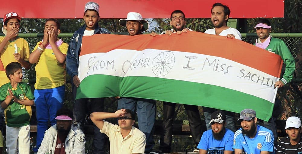 Indian cricket fans sing as they hold their national flag during their 1st One Day International cricket match against South Africa at Wanderers stadium in Johannesburg, South Africa.
