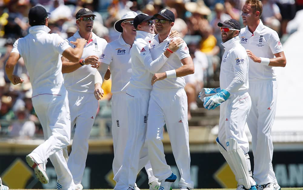 England's James Anderson, center right, is congratulated by team mate Joe Root after running out Australia's Chris Rodgers on the first day of the Ashes cricket test match against Australia in Perth, Australia.