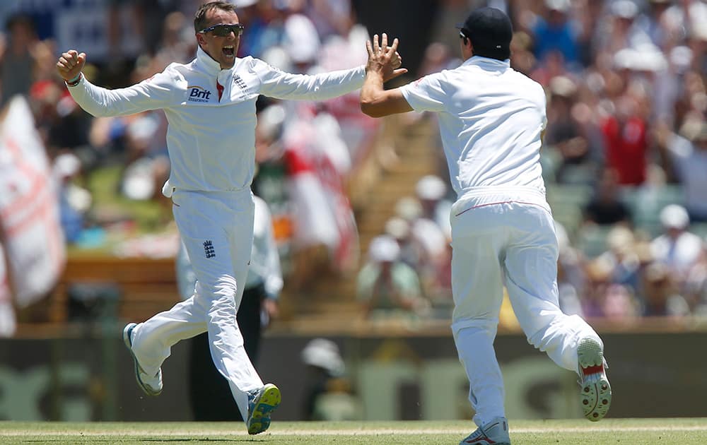 England's Graeme Swann and Alastair Cook celebrate after taking the wicket of Australia's Michael Clarke on the first day of the Ashes cricket test match in Perth, Australia.