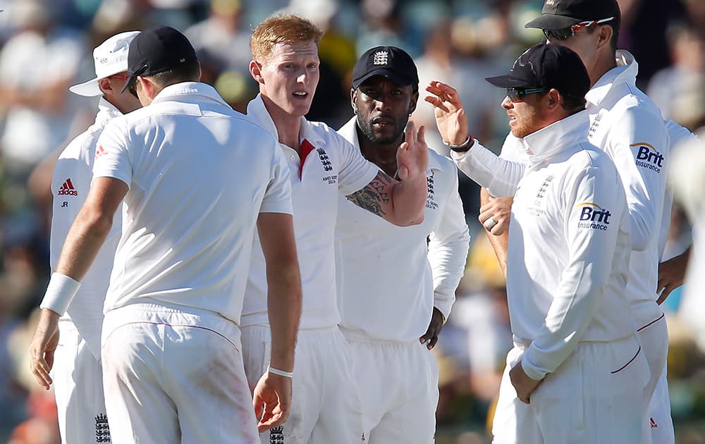 England's Ben Stokes is congratulated by teammates after taking the wicked of Australia's Brad Haddin on the first day of their Ashes cricket test match in Perth, Australia.