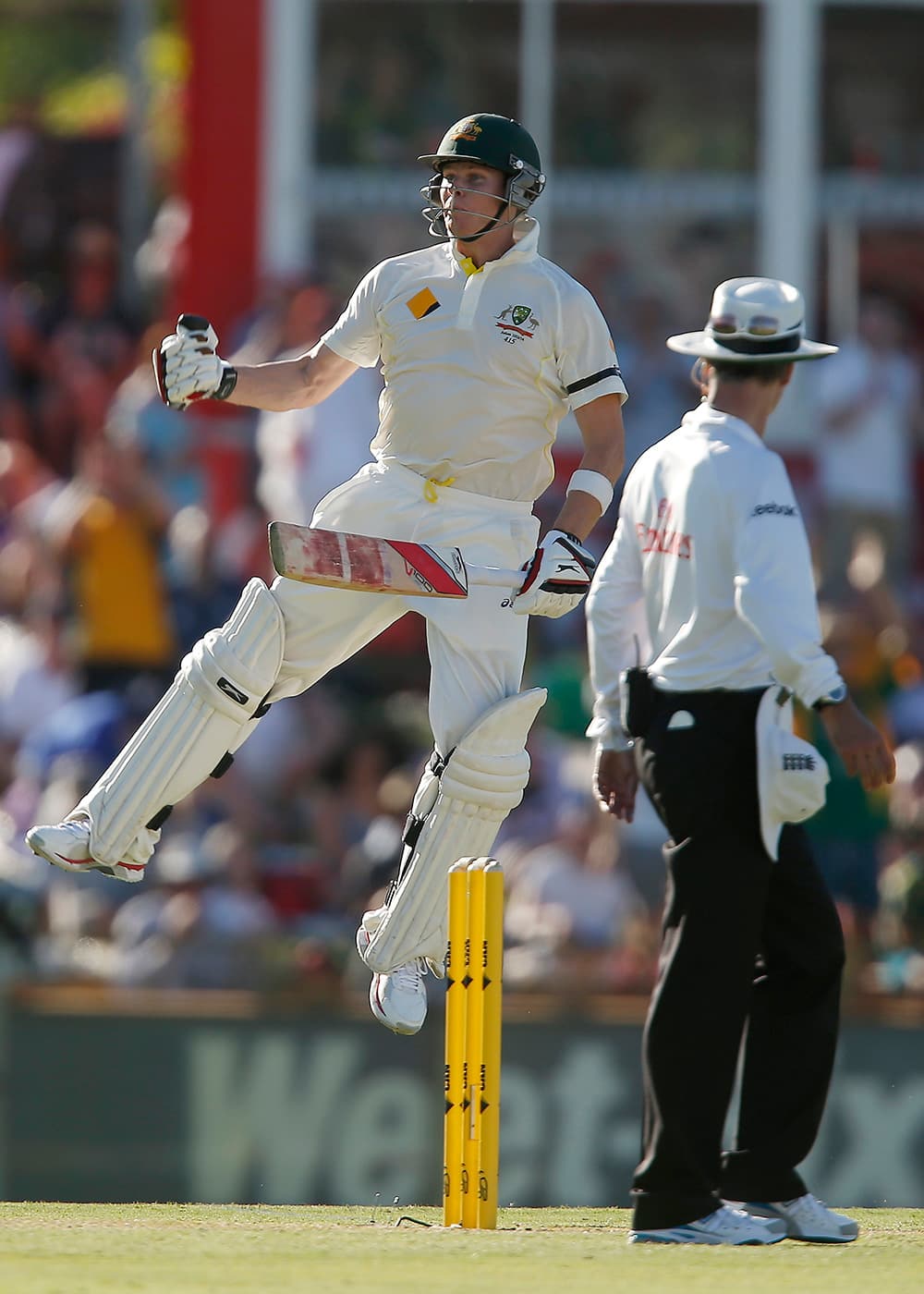 Australia's Steve Smith jumps in the air to celebrate scoring 100 runs against England on the first day of their Ashes cricket test match in Perth, Australia.