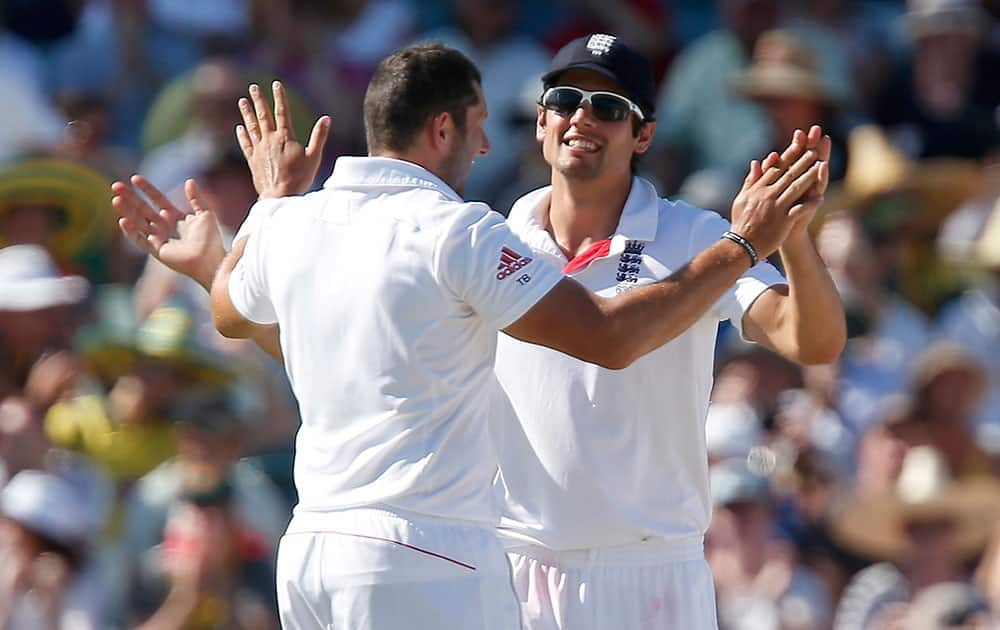 England's Alastair Cook, right, congratulates teammate Tim Bresnan after Bresnan took the wicket of Australia's Chris Rodgers in the second innings on the third day of their Ashes cricket test match in Perth, Australia.