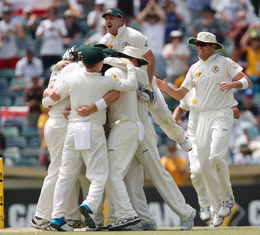 Australian team players celebrate after winning their Ashes cricket test match over England.