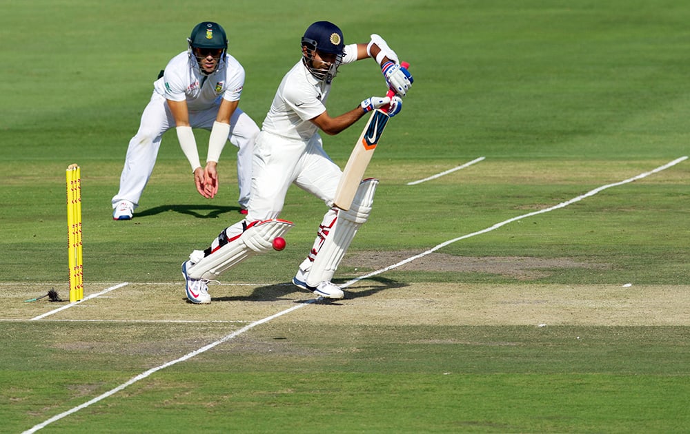 Ajinkya Rahane plays a shot as South Africa's Francois du Plessis, left, looks on during the first day of their cricket test match at Wanderers stadium in Johannesburg, South Africa.