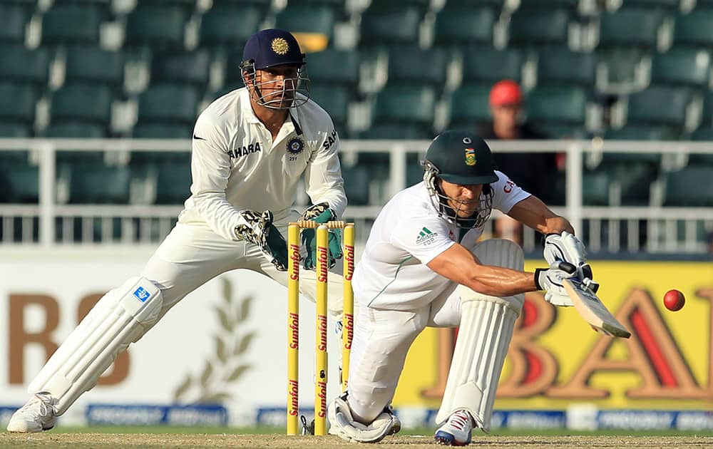 Francois du Plessis, plays a shot as India's captain Mahendra Singh Dhoni during the second day of their cricket test match at Wanderers stadium in Johannesburg, South Africa.