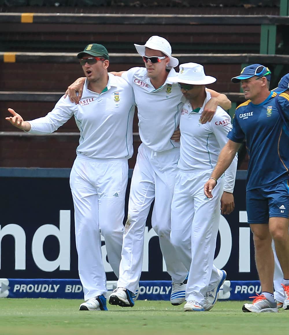 Graeme Smith with Alviro Petersen assist teammate Morne Morkel, after hurting his right ankle during India's 2nd innings on the third day of their cricket test match at Wanderers stadium in Johannesburg, South Africa.