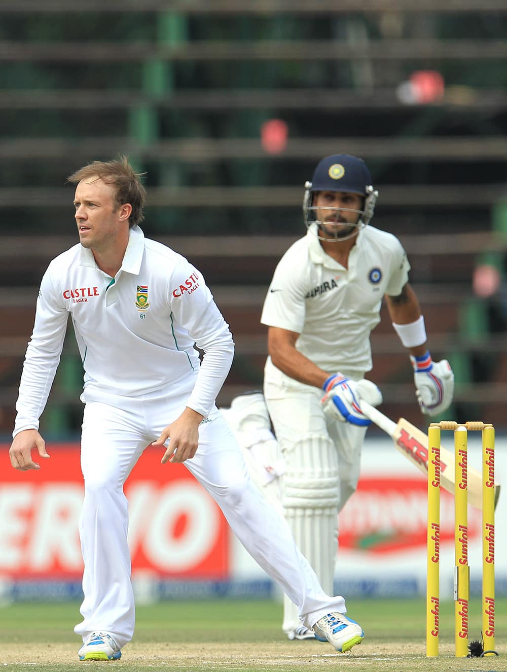Ab de Villiers awaits the ball as Virat Kohli makes a run during India's 2nd innings on the third day of their cricket test match at Wanderers stadium in Johannesburg, South Africa.