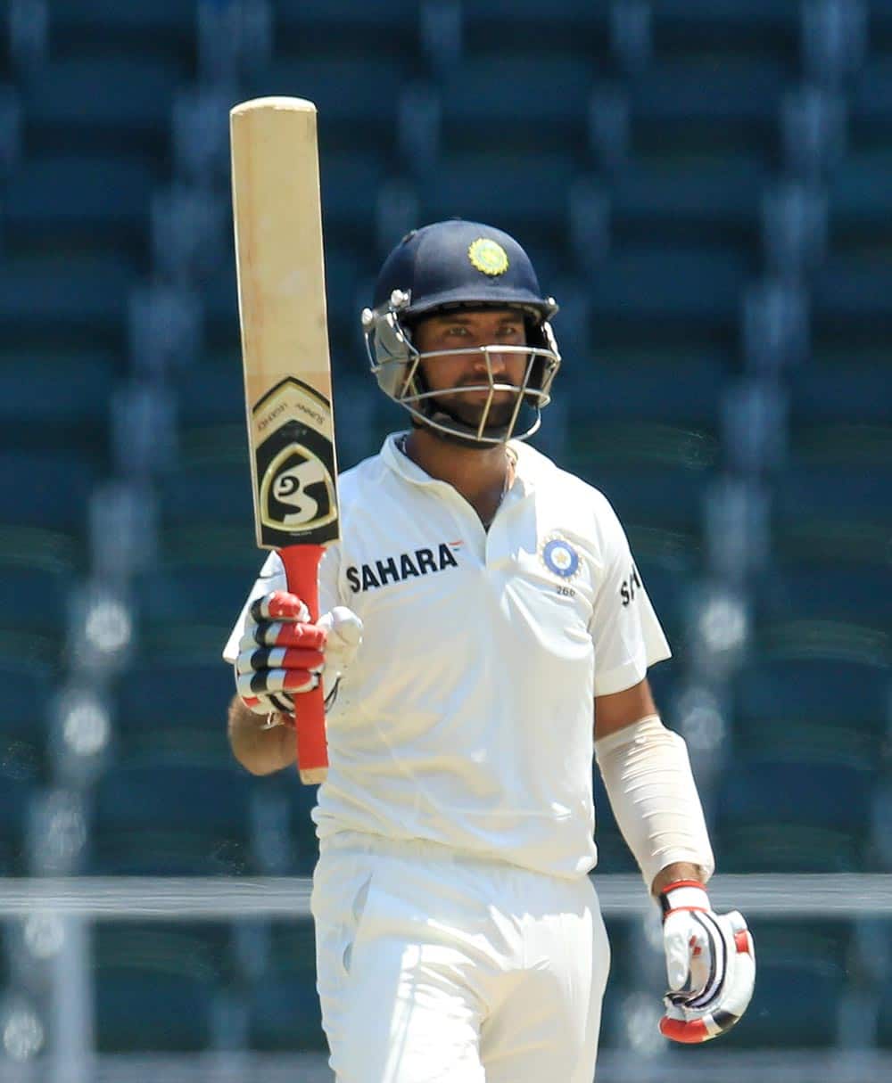 Cheteshwar Pujara raises his bat after reaching 150 runs during the second innings on the fourth day of their cricket test match against South Africa, at Wanderers stadium in Johannesburg.