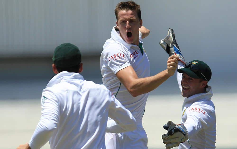 South Africa's bowler Morne Morkel, center, celebrates with teammates after dismissing India's batsman Shikhar Dhawan, for 29 runs during first day of their cricket test match at Kingsmead stadium, Durban, South Africa.