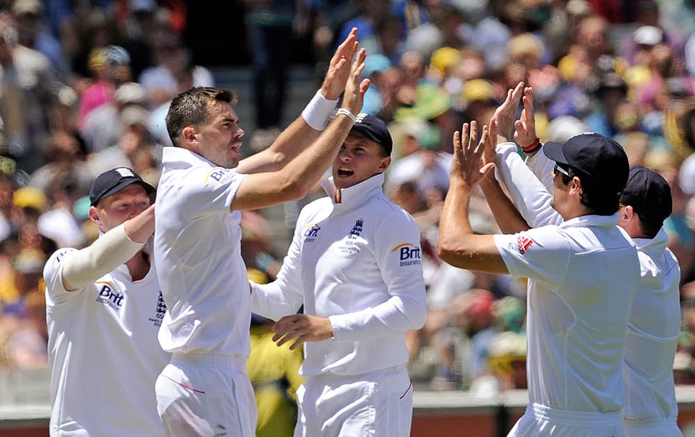 England's James Anderson celebrates with teammates after bowling out Australia's Michael Clarke for 10 runs during their Ashes cricket test match at the Melbourne Cricket Ground in Melbourne, Australia.