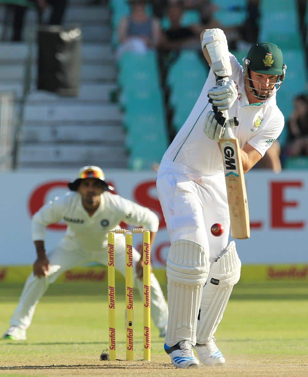 South Africa's captain Graeme Smith, right, plays a shot as India's fielder Murali Vijay, left, watches during second day of their cricket test match at Kingsmead stadium, Durban, South Africa.
