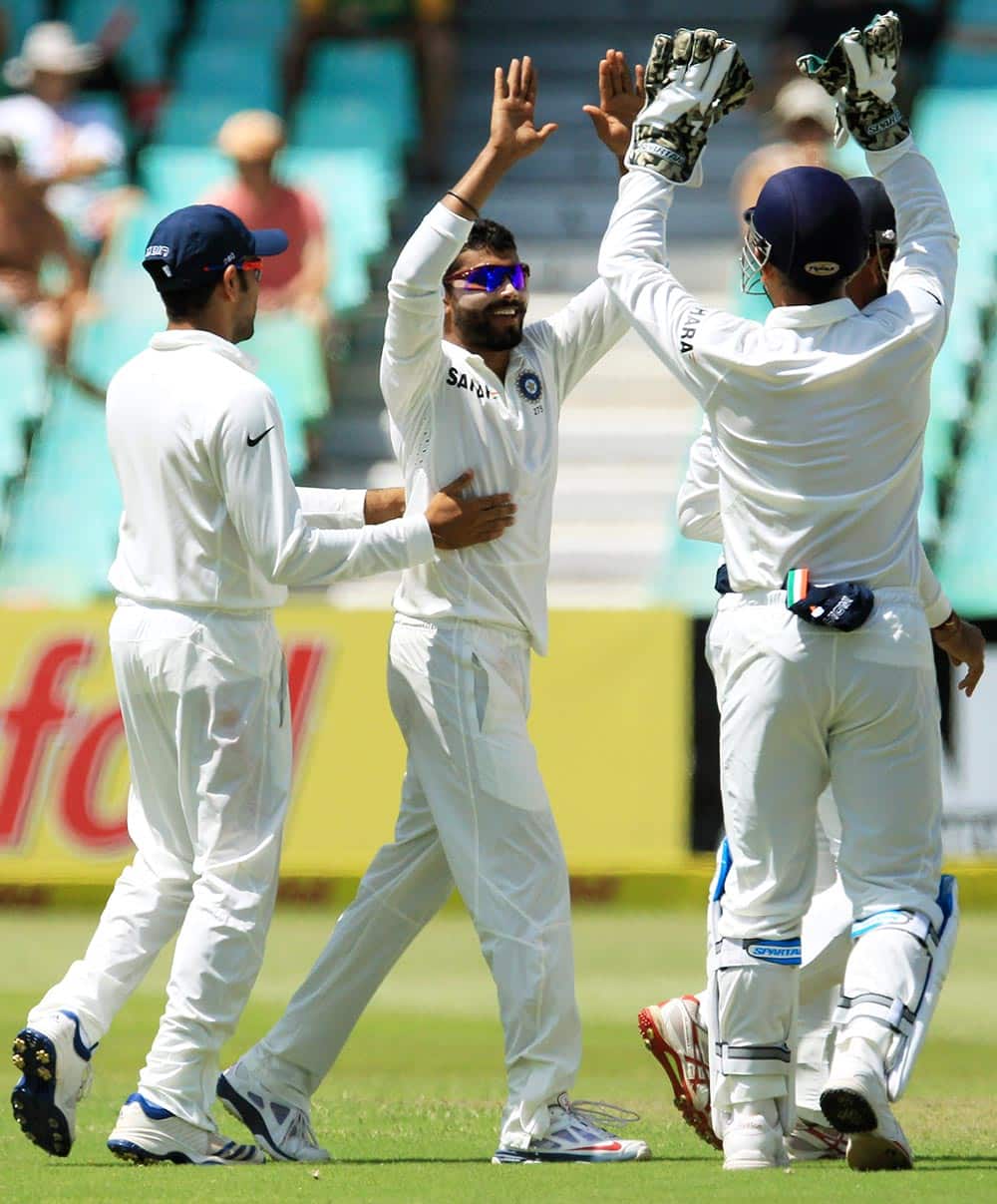 India's bowler Ravindra Jadeja, center, celebrates with teammates after dismissed South Africa's captain Graeme Smith, for 47 runs during the second day of their cricket test match at Kingsmead stadium, Durban.