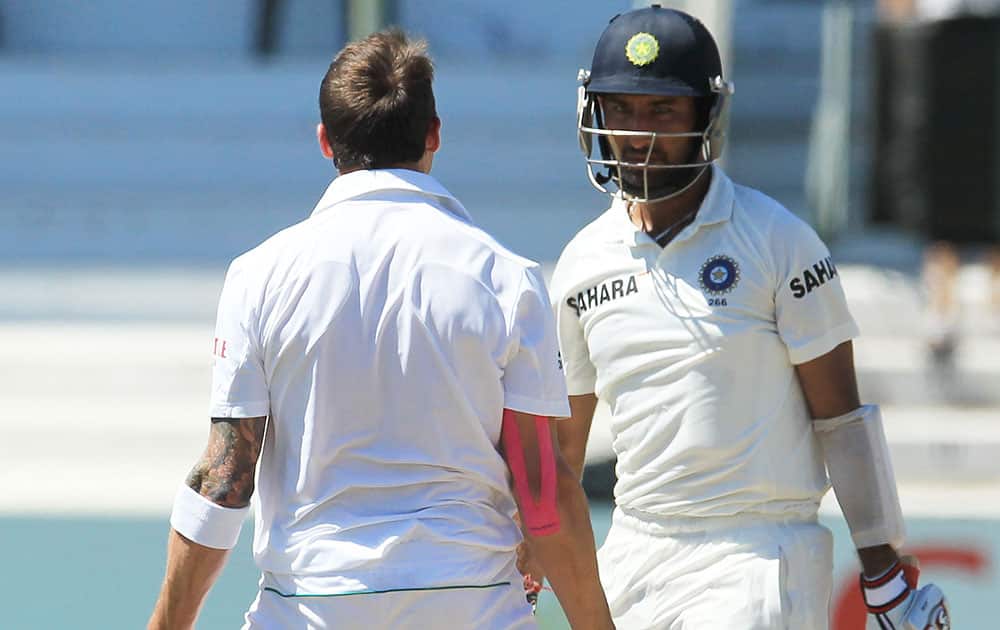 India's batsman Cheteshwar Pujara, right, watches as South Africa's bowler Dale Steyn, left, celebrates after bowling him for 32 runs on the firth and final day of their cricket test match at Kingsmead stadium, Durban, South Africa.