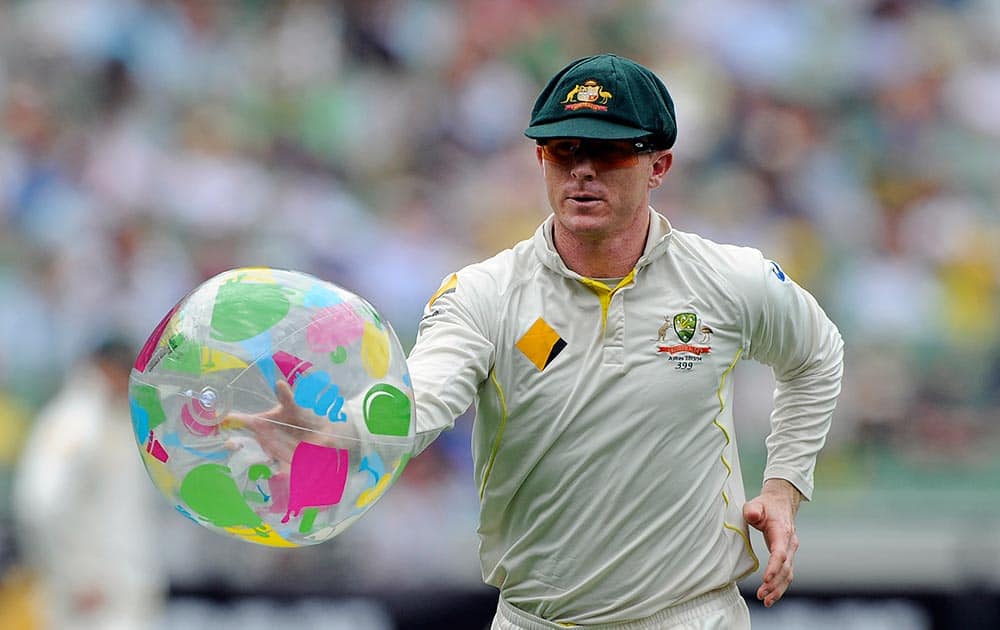 Australia's Chris Rogers removes a beach ball from the field during their Ashes cricket test match against England.