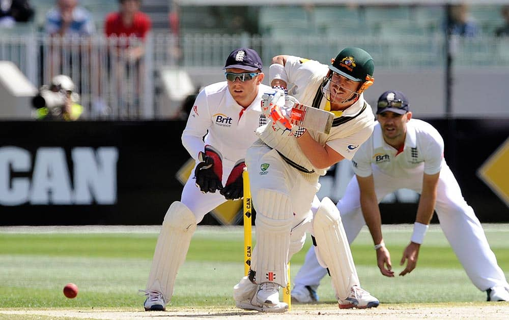 England's Jonny Bairstow, left, and James Anderson, right, watch as Australia's David Warner pulls the ball during their Ashes cricket test match.