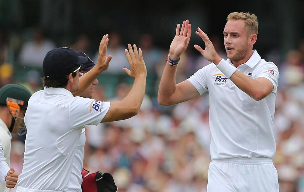 England cricket captain Alastair Cook, left, celebrates with his teammate Stuart Broad, right, after bowling out Australia's David Warner during their Ashes cricket test match at the Sydney Cricket Ground in Sydney.