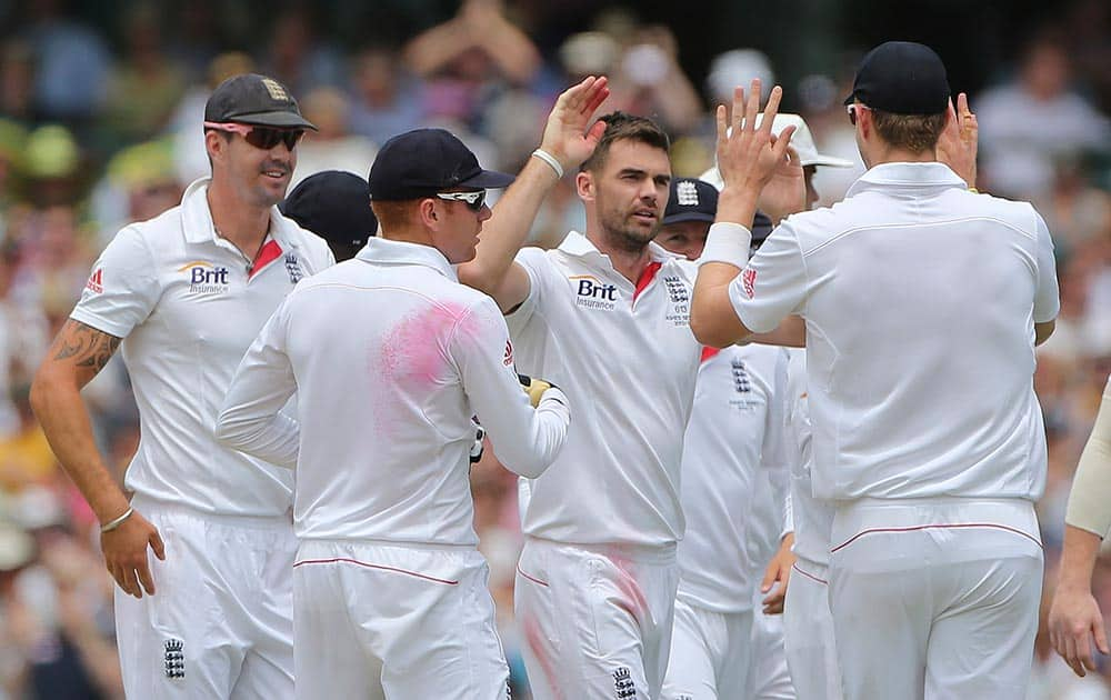 England cricket player James Anderson, center, celebrates with team mates after taking the wicket of Australia's Shane Watson on the first day of play during their Ashes cricket test match in Sydney.